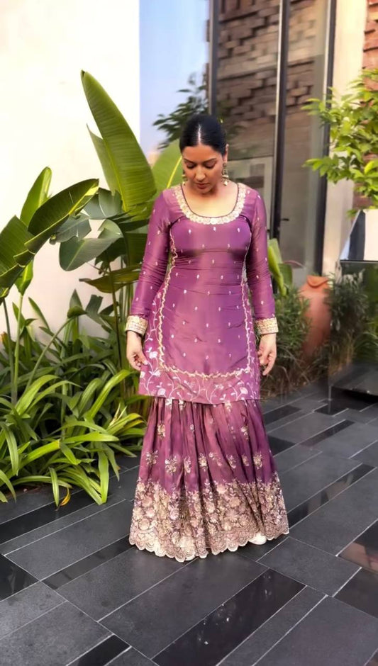 A Stylish Woman Adorned in a Pink Dress Standing Poised on a Charming Outdoor Patio